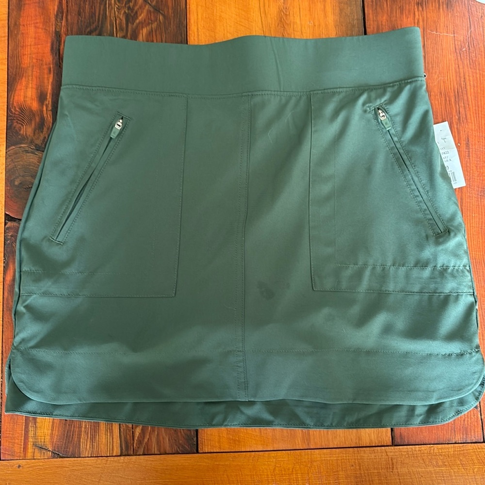 Green athletic skirt with under shorts. Multiple pockets. Size small